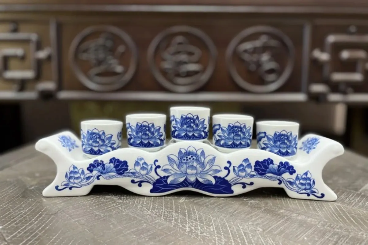 Khay 5 chén nước xếp hình chữ thập trên bàn thờ Thần Tài, tượng trưng Ngũ Hành và Ngũ Phương.